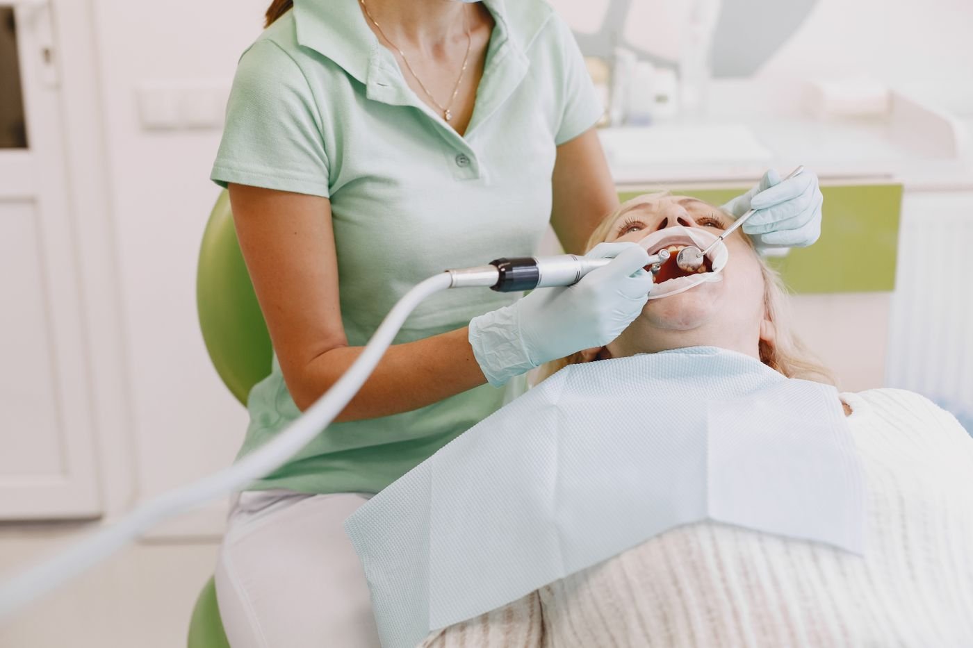 Dental hygienist performing a gentle teeth cleaning for a patient in Aurora