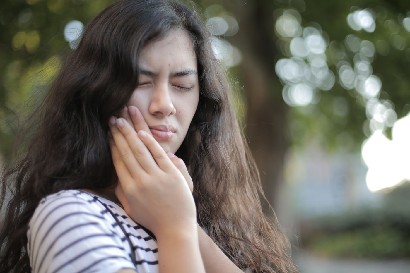 Woman awake at night with a throbbing toothache before calling an Aurora dentist